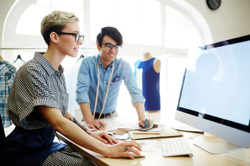 Young fashion designer browsing in the net and looking for information about new trends