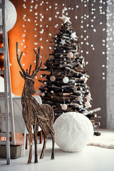 Stylish Christmas interior decorated in rustic style. Handmade festive decorations. Home family comfort. Wooden deer close up.