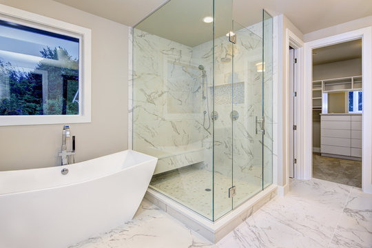 Sleek bathroom features freestanding bathtub