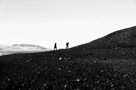 Black and White photo of two tourists walking up on the stone hill