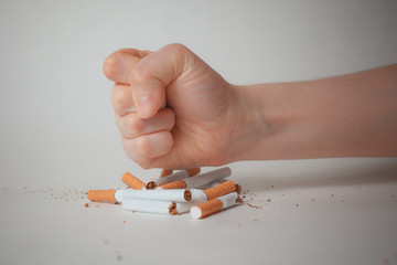 Man's hand crushing cigarettes. quit Smoking.