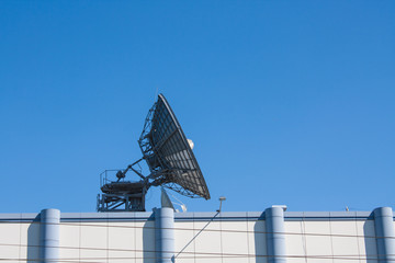 Satellite Dish Antenna on Top of Building, Blue Sky Background