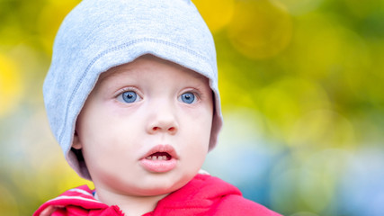 closeup of one year old boy with defocused green natural background