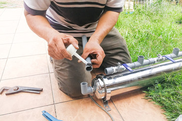 Series of plumber fixing up ourdoor water filter with pvc piping
