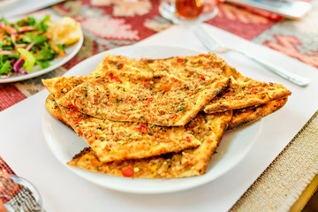 Sliced Lahmacun on a plate in turkish cafe or restaurant