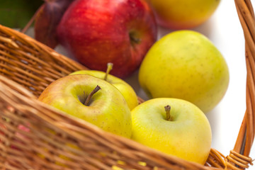 apples in a wicker basket on a white background.