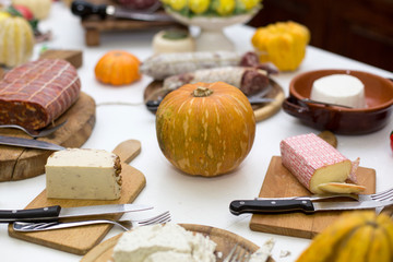 Fototapeta na wymiar Zucca formaggi e salumi su tavolo con tovaglia bianca