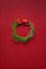 Christmas wreath / Creative concept photo of christmas wreath made of tree on red background. © Fisher Photostudio