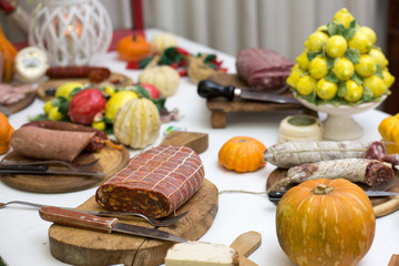 Zucca, agrumi e salumi italiani su tavolo con tovaglia bianca