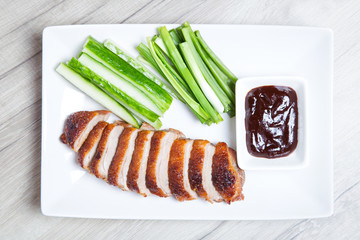 Baked duck with hoisin sauce, cucumbers and shallots. Selective focus, close-up.