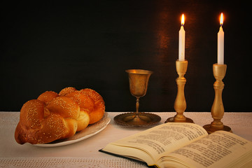 shabbat image. challah bread, shabbat wine and candles on the table.