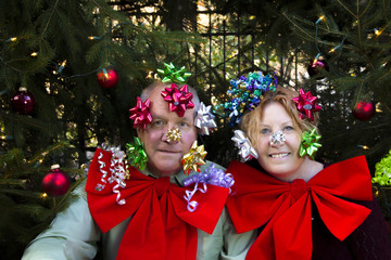Couple with bows under Christmas tree
