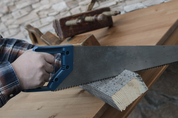 Carpenter working with hacksaw