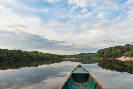 Reflections of sky and trees on the waters of the Sipapo river, in the amazon jungle.