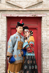 Fototapeta na wymiar Young Mongolian couple in a traditional 13th century costume in a temple. Ulaanbaatar, Mongolia.