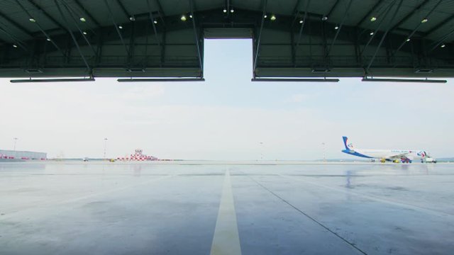 Airplane hangar. Check-out of aircraft hangar. Airport hangar from the inside with big tall doors