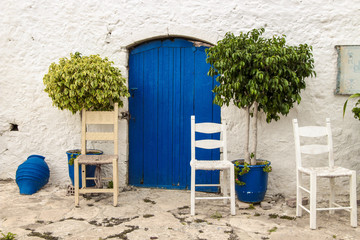 Kreta, Chersonissos,  Blaue Tür und Holzstühle