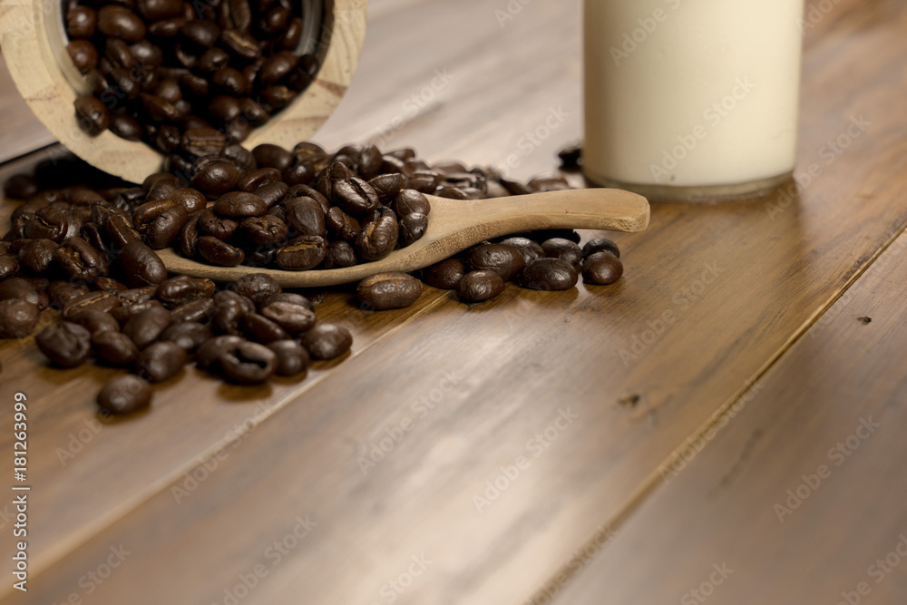 Wall mural Coffee bean grain ,bottle of milk and sack fabrice board on brown wood table background , include copyspace for add text or graphic in advertise or marketing content