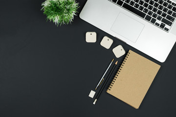 Business office work desk table with computer laptop , note and stationery on black table background include copyspace for add text or graphic