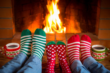 Family in Christmas socks near fireplace