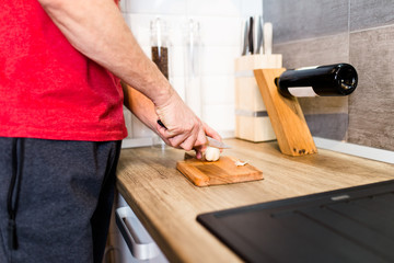 Single young handsome man alone at home preparing dinner.