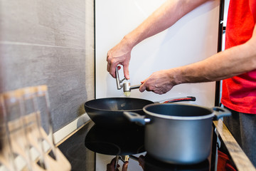 Single young handsome man alone at home preparing dinner.