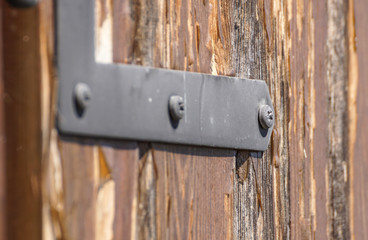 wood screws in metal hinged iron. selective focus