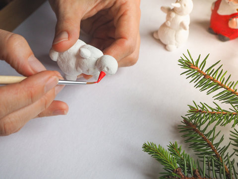 Artist is working in an atelier. Art and small sculpture snowman. Preparing for Christmas.

