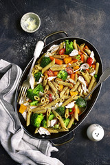 Whole grain penne pasta with vegetable and roasted chicken.Top view.