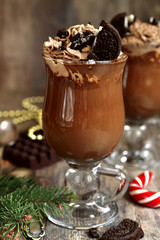 Festive hot chocolate with whipped cream and cookies.