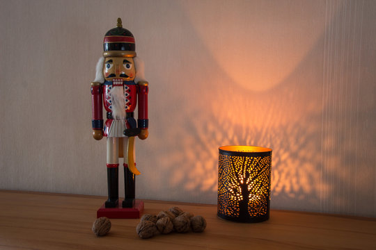 Nussknacker mit N&uuml;ssen und einem Lichtspiel als Dekoration zu Weihnachten und im Advent im Querformat