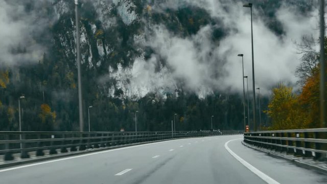 POV DRIVING PLATE Car driving on a scenic mountain highway, clouds flying low. 4K UHD