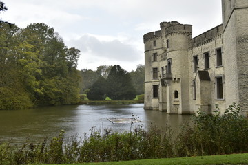 Les tourelles en pierres calcaires du château de Bouchout et l'étang principal sous la pluie au...