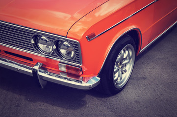 Old vintage car orange color on the gray asphalt