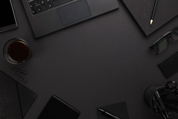 Laptop and Office Supplies At Dark Gray Desk - Powered by Adobe