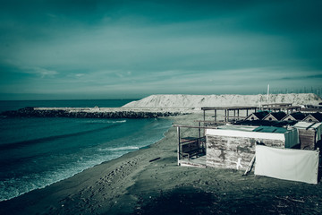 Il mare e la spiaggia abbandonata: immagine con toni freddi e drammatici