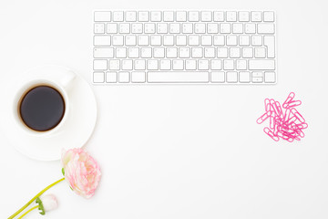 A white keyboard and a cup of black coffee on a white background. Styled mockup