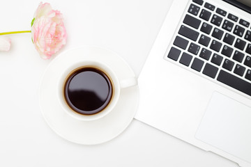 Cup of coffee and laptop keyboard on white background. Flat lay
