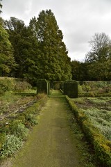 Chemin vers les haies carrées et l'un des coins du jardin de l'Orangerie entouré par un mur d'enceinte sous un ciel d'automne ,au Jardin Botanique National de Belgique à Meise