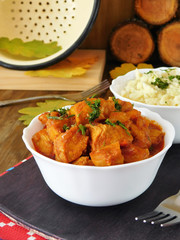 Meat stewed in tomato sauce. Porkolt, Hungarian cuisine meal. Nokedli, a type of egg noodle in the background