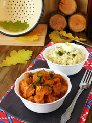 Meat stewed in tomato sauce. Porkolt, Hungarian cuisine meal. Nokedli, a type of egg noodle in the background