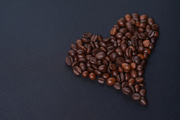 Heart made of coffee beans on dark background