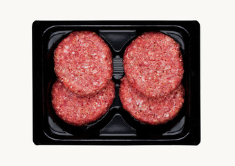 Raw fresh beef burgers in plastic tray