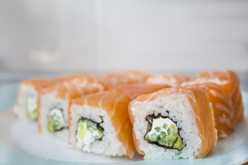 Homemade sushi roll with salmon, cream cheese Philadelphia, seaweed and avocado on the plate. Selective focus. concept of Japanese food.