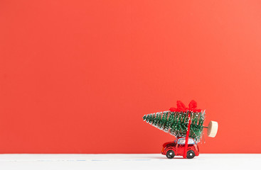 a toy car carries a Christmas tree