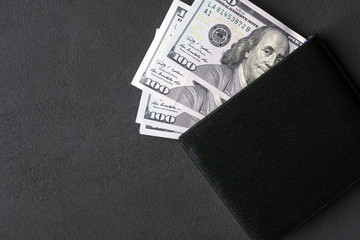 American dollars in wallet on a dark background
