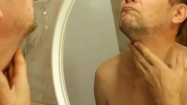 the man touches the bristles on his face