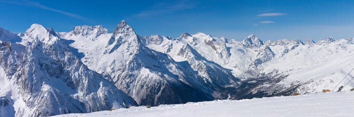 Fototapeta na wymiar Snow covered the ski slopes against the backdrop of the mountain peaks.