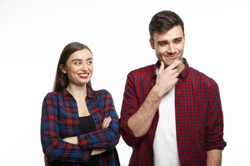 Stylish young European family man and woman in love standing close to each other, showing different...