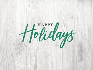Festive Happy Holidays Calligraphy Text Over White Rustic Wood Background